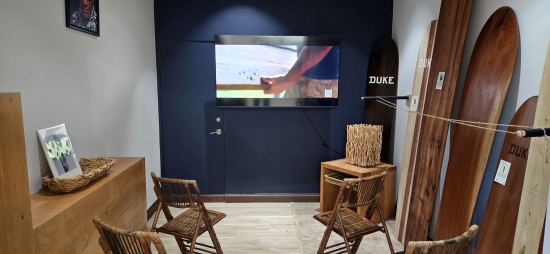 The film alcove: a screen on a dark blue wall, wooden chairs, and boards leaning beside it.