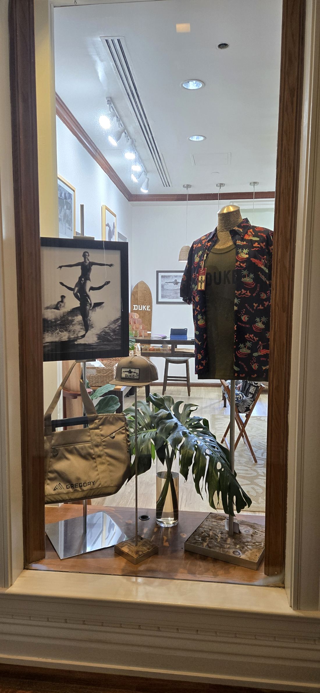 A tall arched display case with an aloha shirt on a form.