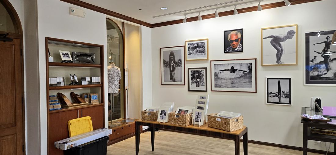 The exhibition wall: framed black and white photographs of Duke above a long wooden table.