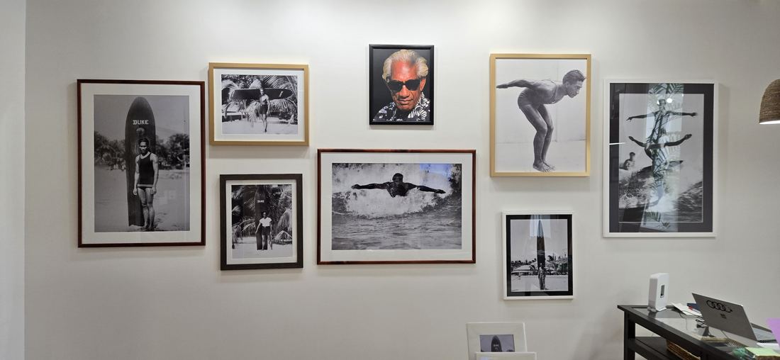 Framed photographs of Duke hung together on a white wall.